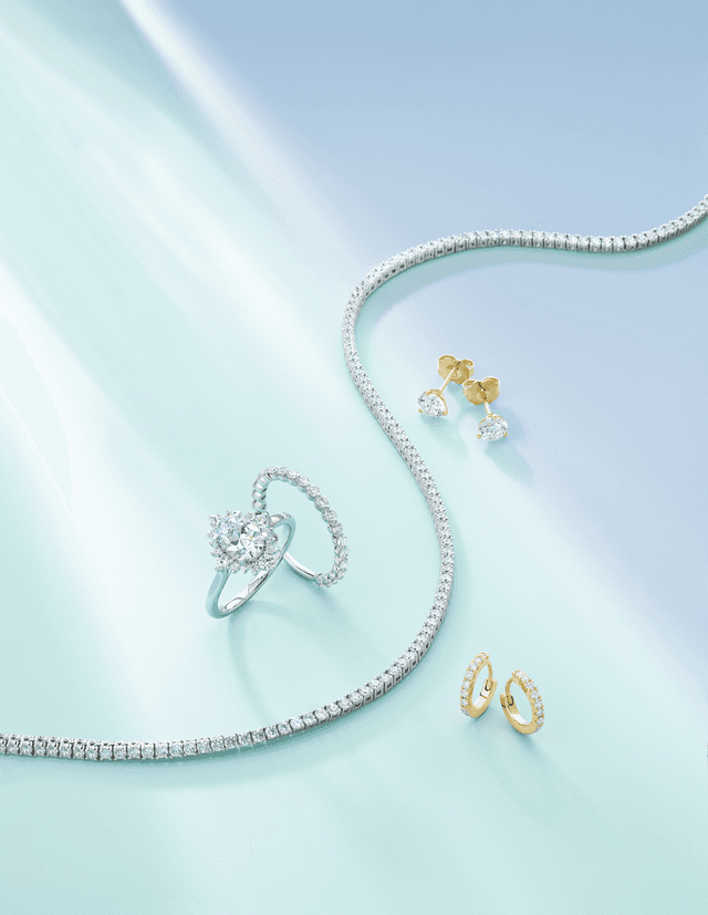 Motek Jewelry round halo diamond engagement ring, matching eternity band, tennis necklace, and stud earrings.