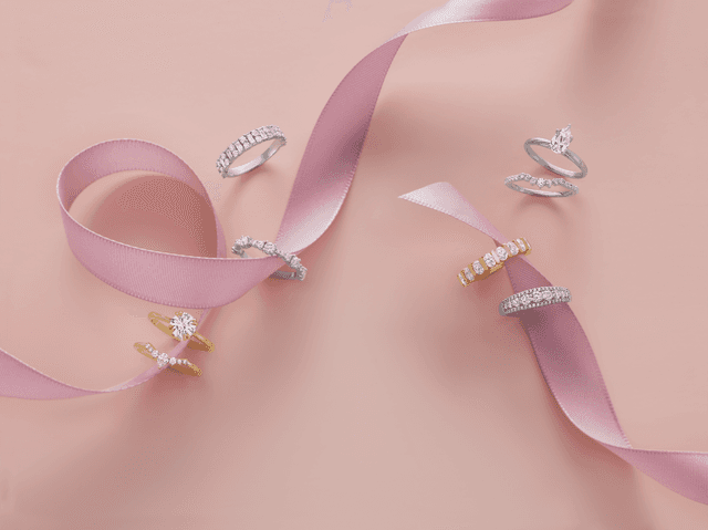 Motek Jewelry diamond engagement rings and wedding bands displayed across a soft pink ribbon.